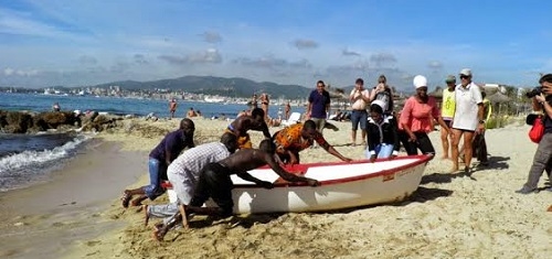 Activistas de Amnistía Internacional hacen un simulacro de desembarco en la playa de Can Pere Antoni